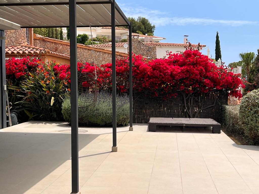 Elegante terraza con flores rojas y diseño moderno